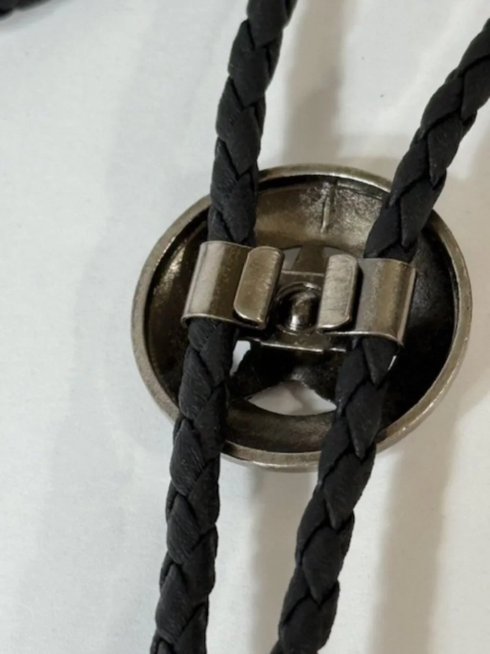 Silver-tone sheriff star and black cord western cowboy bolo tie.